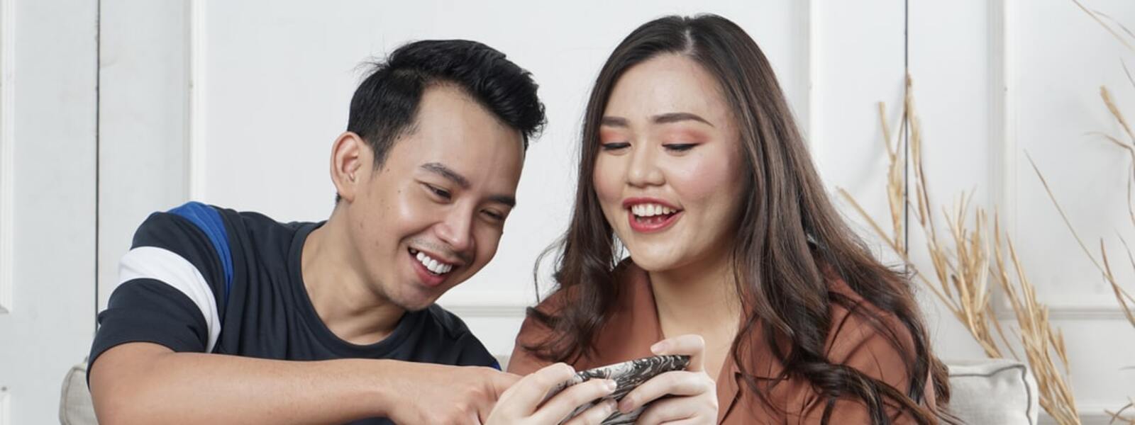 Man and girl looking at smartphone screen and laughing